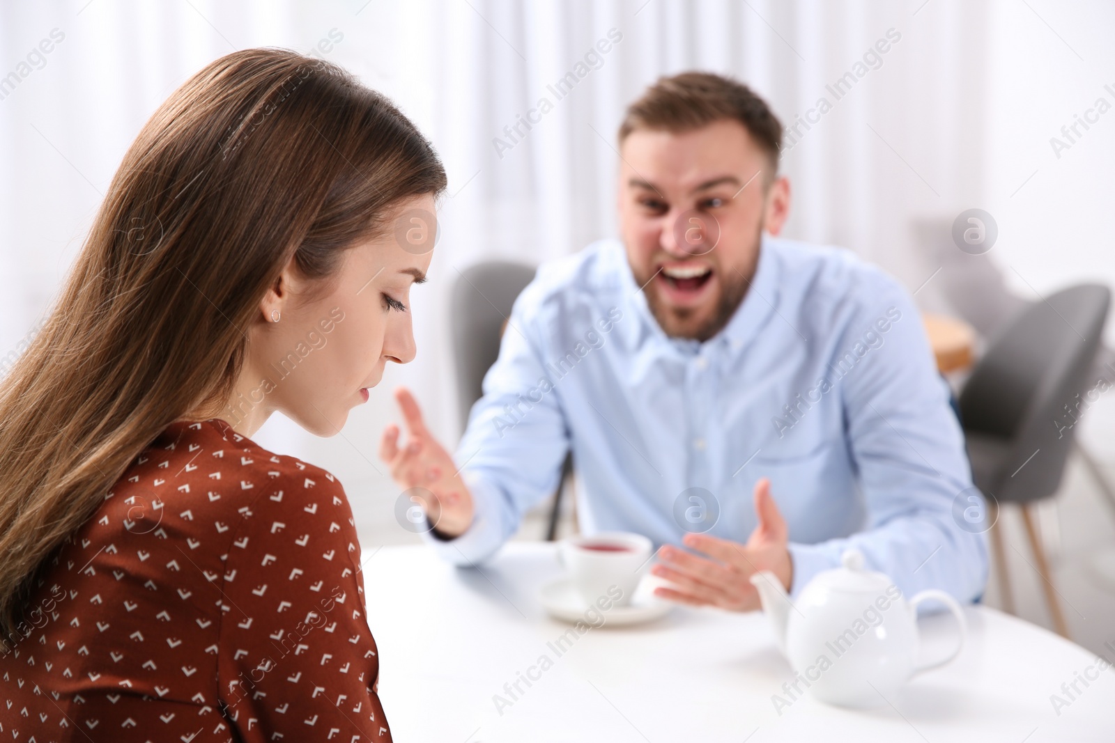 Photo of Couple having quarrel in cafe. Relationship problems