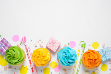 Photo of Flat lay composition with colorful birthday cupcakes on white background. Space for text