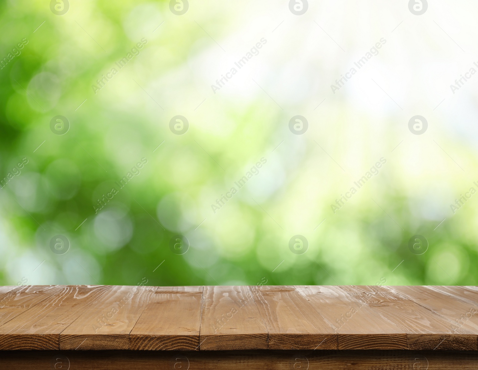 Image of Empty wooden surface against blurred green background. Space for design