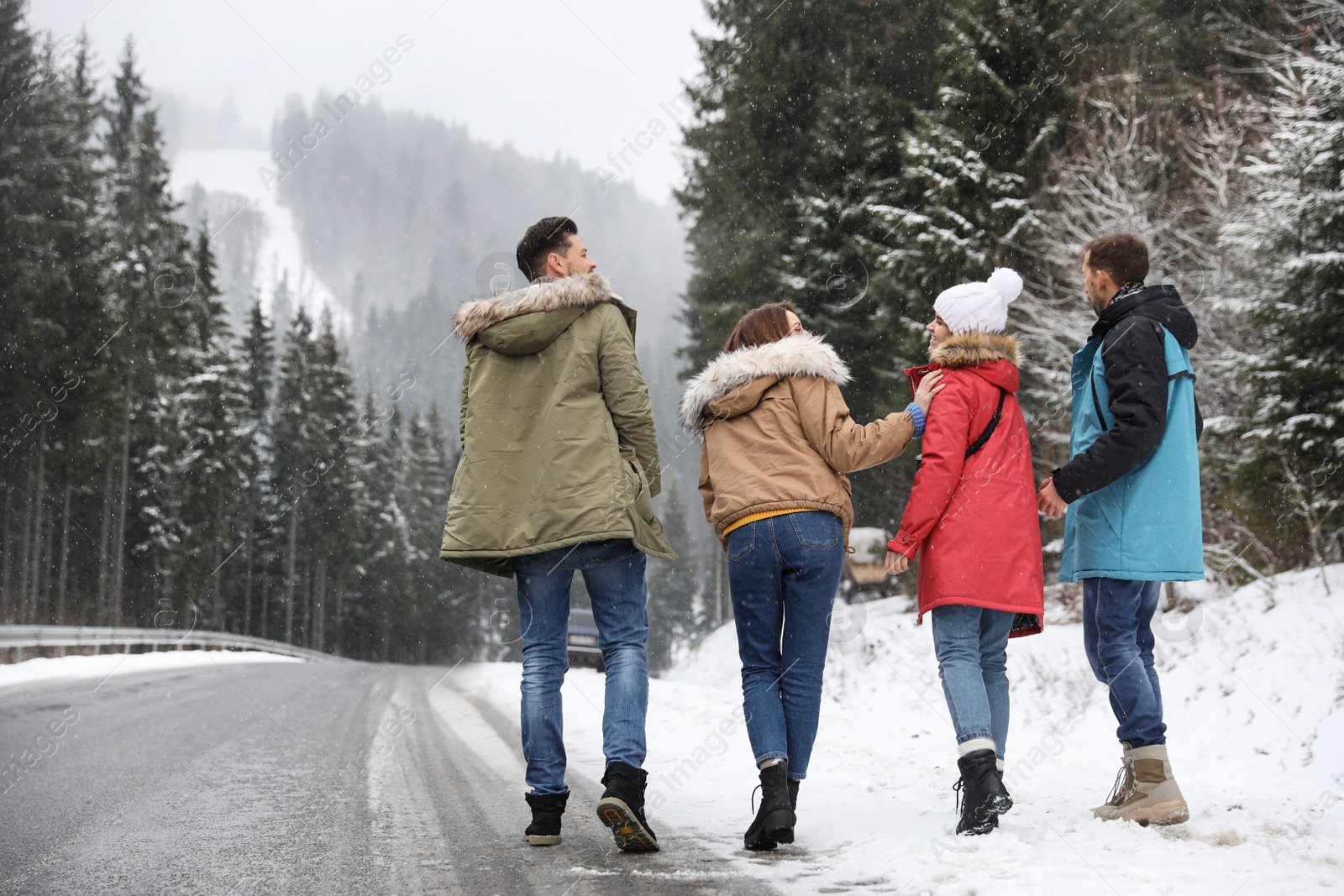 Photo of Group of friends walking near snowy forest. Winter vacation