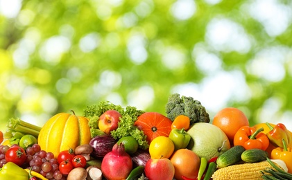 Image of Assortment of fresh organic vegetables and fruits on blurred green background