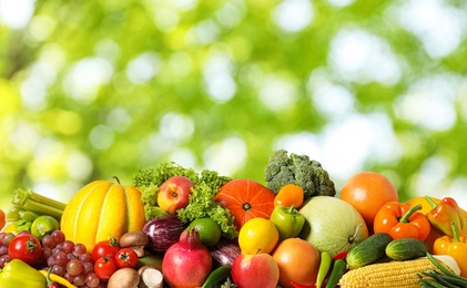 Assortment of fresh organic vegetables and fruits on blurred green background