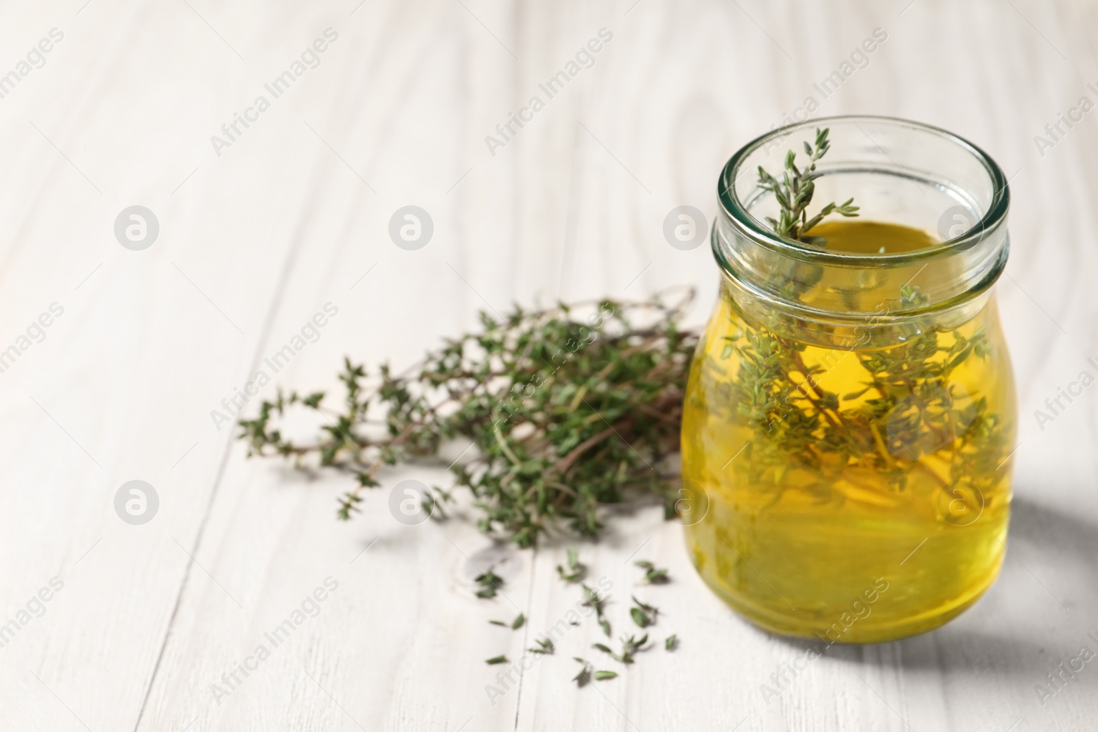 Photo of Aromatic herbal tea with thyme on white wooden table, space for text