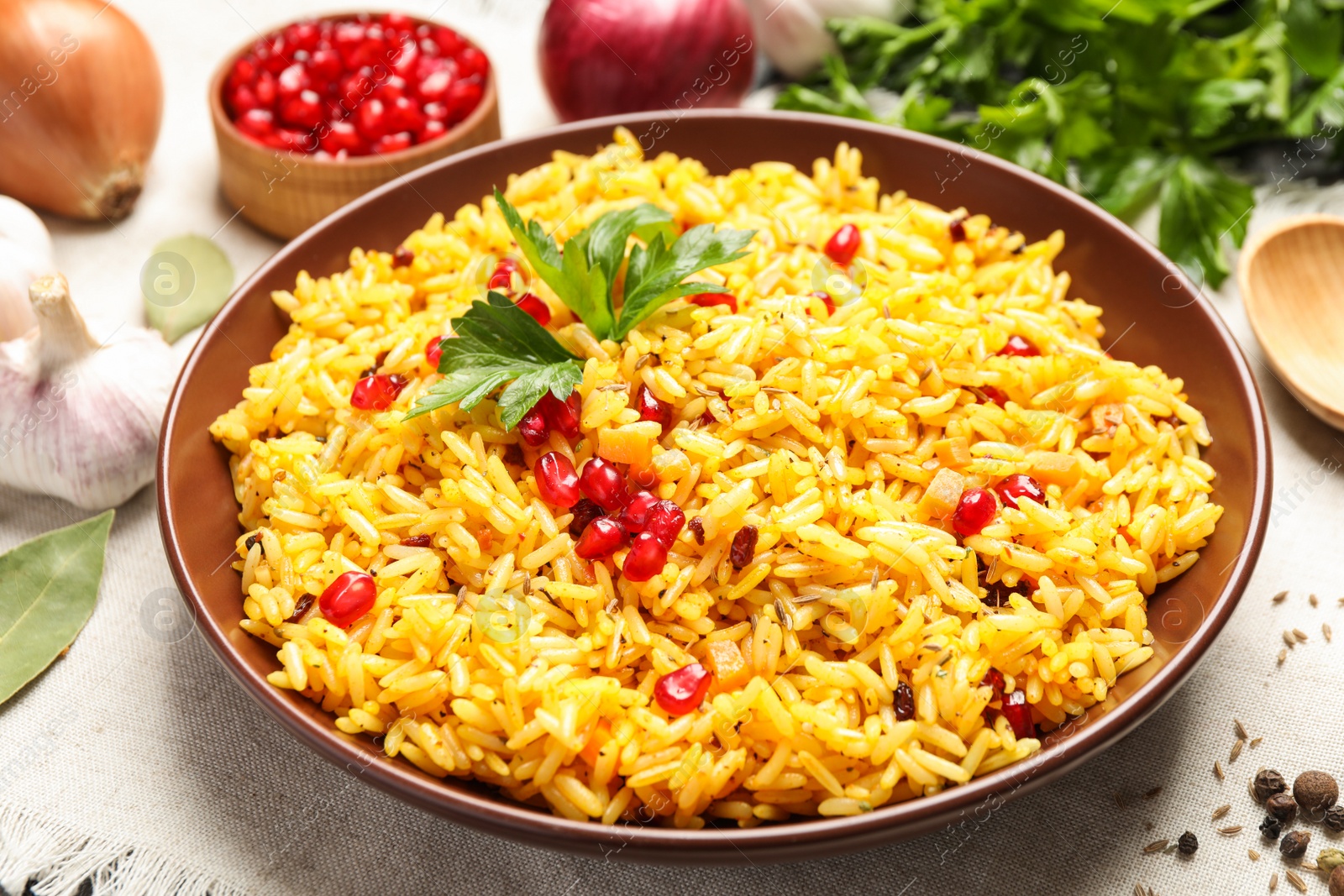 Photo of Tasty rice pilaf with pomegranate grains on table, closeup