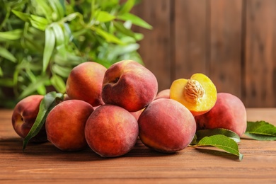 Photo of Fresh sweet ripe peaches on wooden table