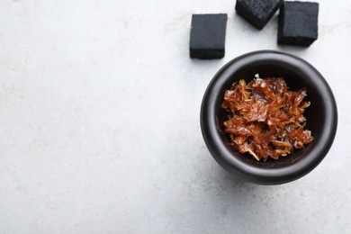 Modern hookah bowl with tobacco and charcoal cubes on light grey table, flat lay. Space for text