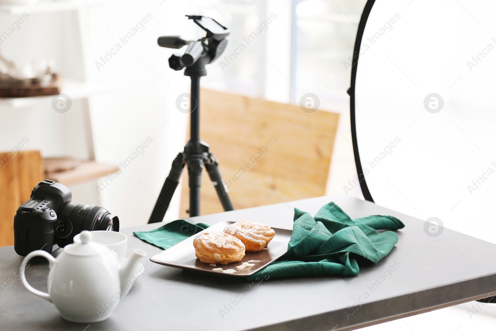 Photo of Professional camera and food composition on table in photo studio