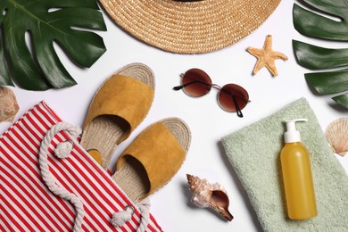 Photo of Flat lay composition with bag, green leaves and other beach accessories on white background