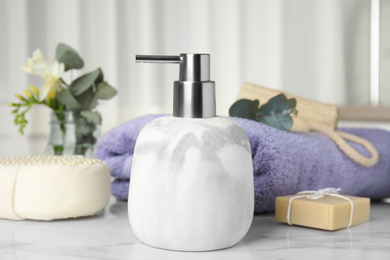 Photo of Soap dispenser and toiletries on white marble table