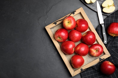 Photo of Fresh ripe red apples on black table, flat lay. Space for text