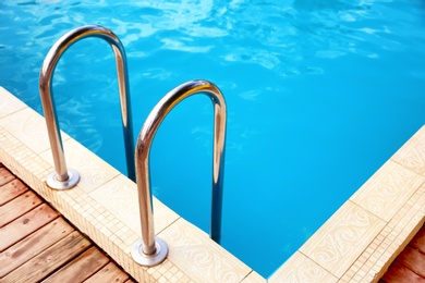 Modern swimming pool with step ladder at resort