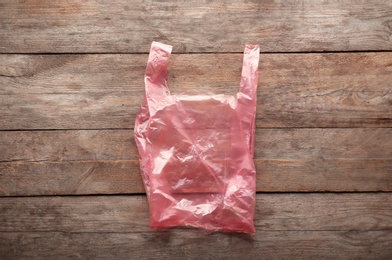 Photo of Clear disposable plastic bag on wooden background