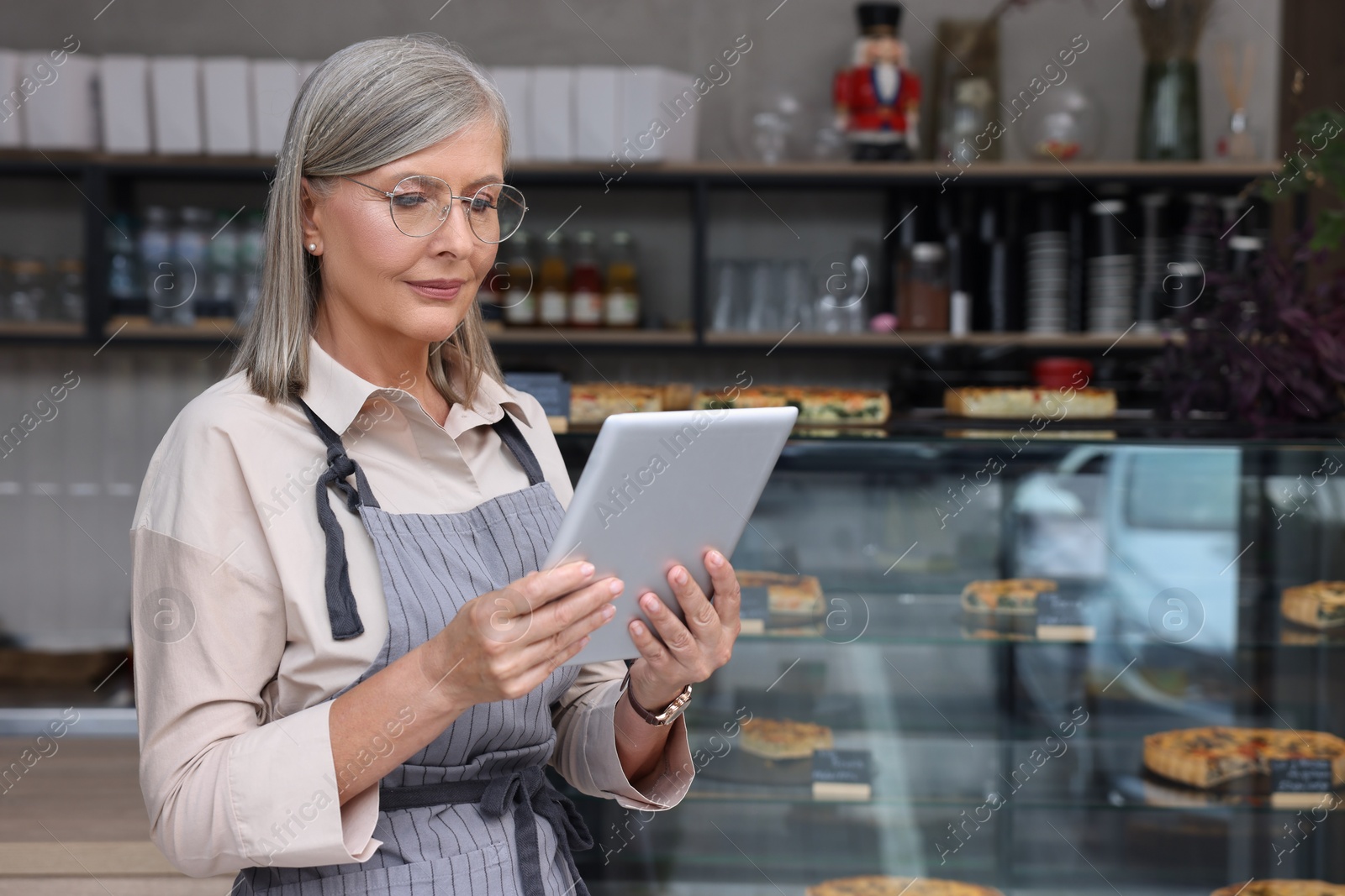 Photo of Business owner using tablet in her cafe, space for text