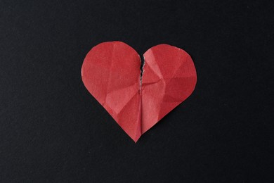 Photo of Crumpled torn paper heart on black background, top view. Breakup concept