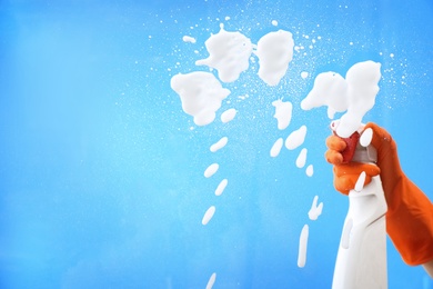 Photo of Woman cleaning glass against color background