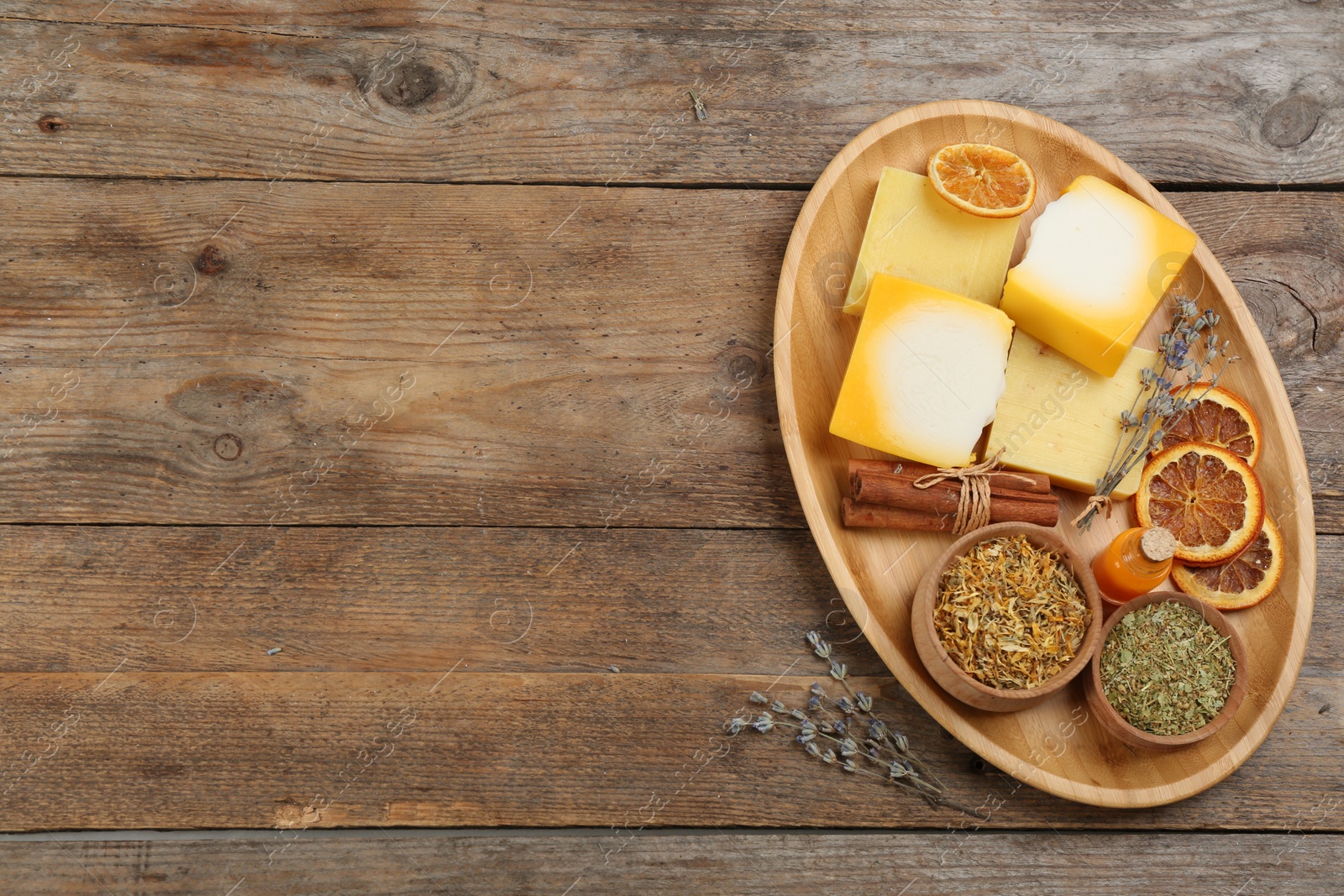 Photo of Flat lay composition with natural handmade soap and ingredients on wooden table, space for text