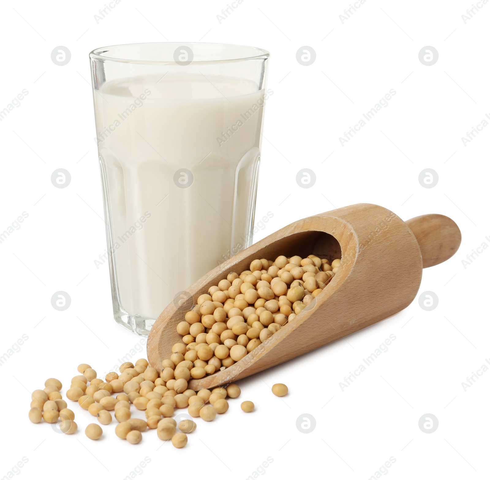 Photo of Glass of fresh soy milk and scoop with beans on white background