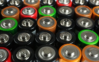 Photo of Many different batteries as background, closeup view