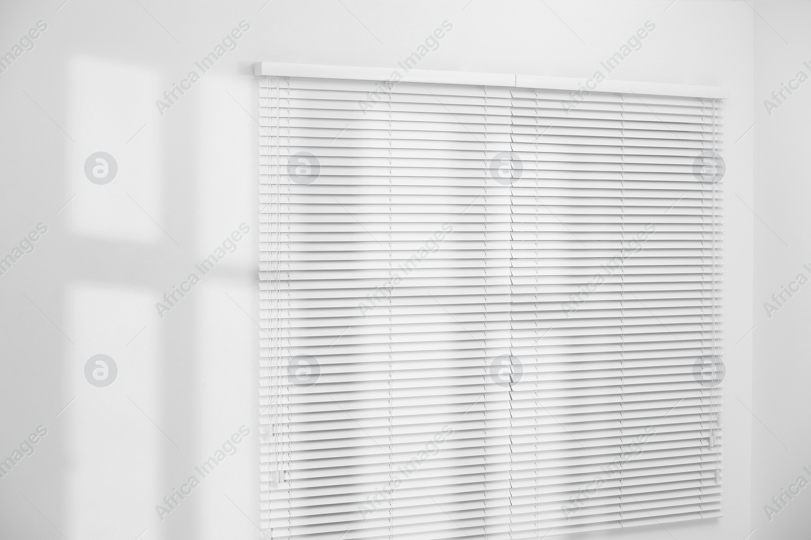 Photo of Light and shadows from window on wall indoors