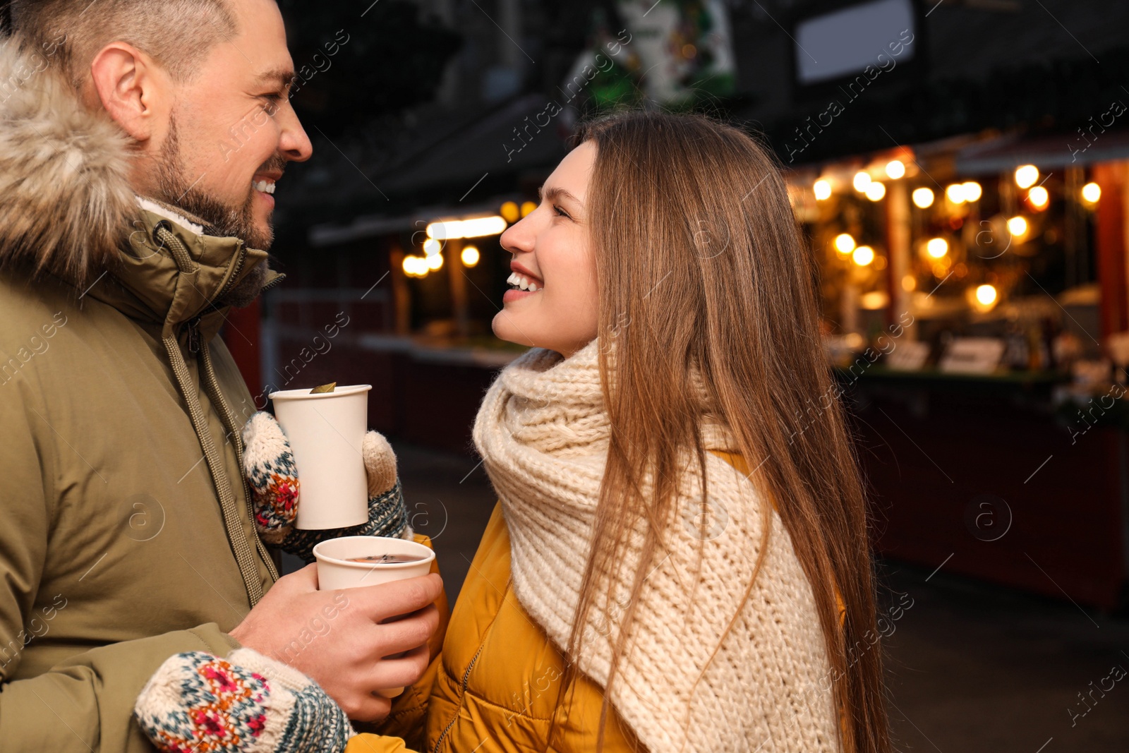 Photo of Happy couple with mulled wine at winter fair