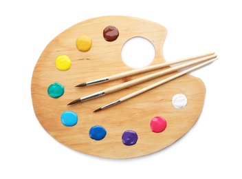 Photo of Palette with paints and brushes on white background, top view