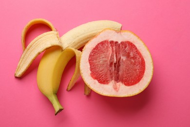 Banana and half of grapefruit on pink background, flat lay. Sex concept