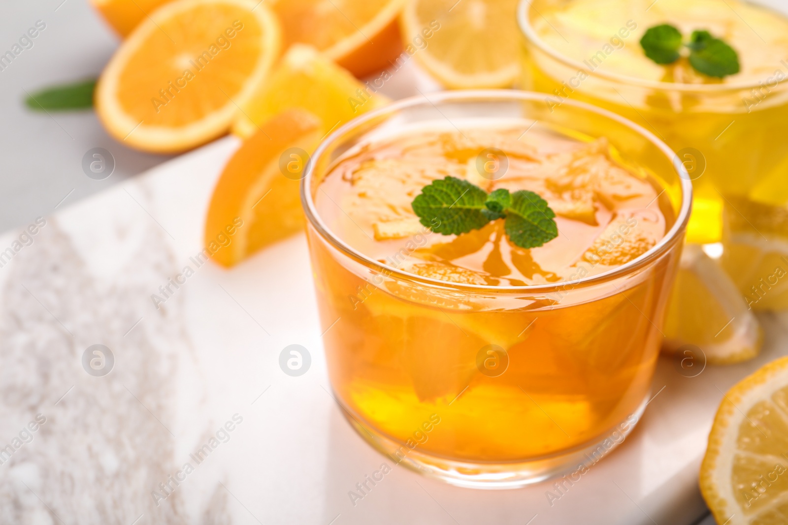 Photo of Glasses of tasty jelly served on light table. Space for text