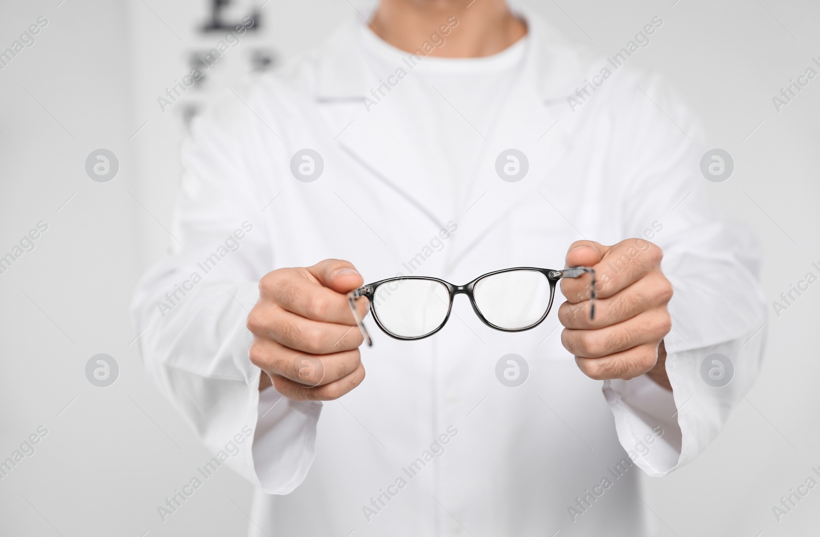 Photo of Male ophthalmologist with eyeglasses in clinic, closeup