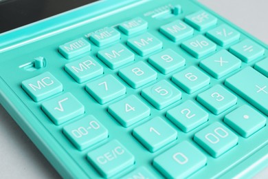 Photo of Closeup view of turquoise calculator on light background