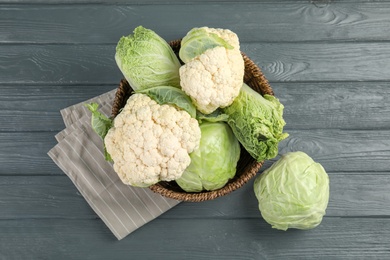 Flat lay composition with different cabbages on wooden background