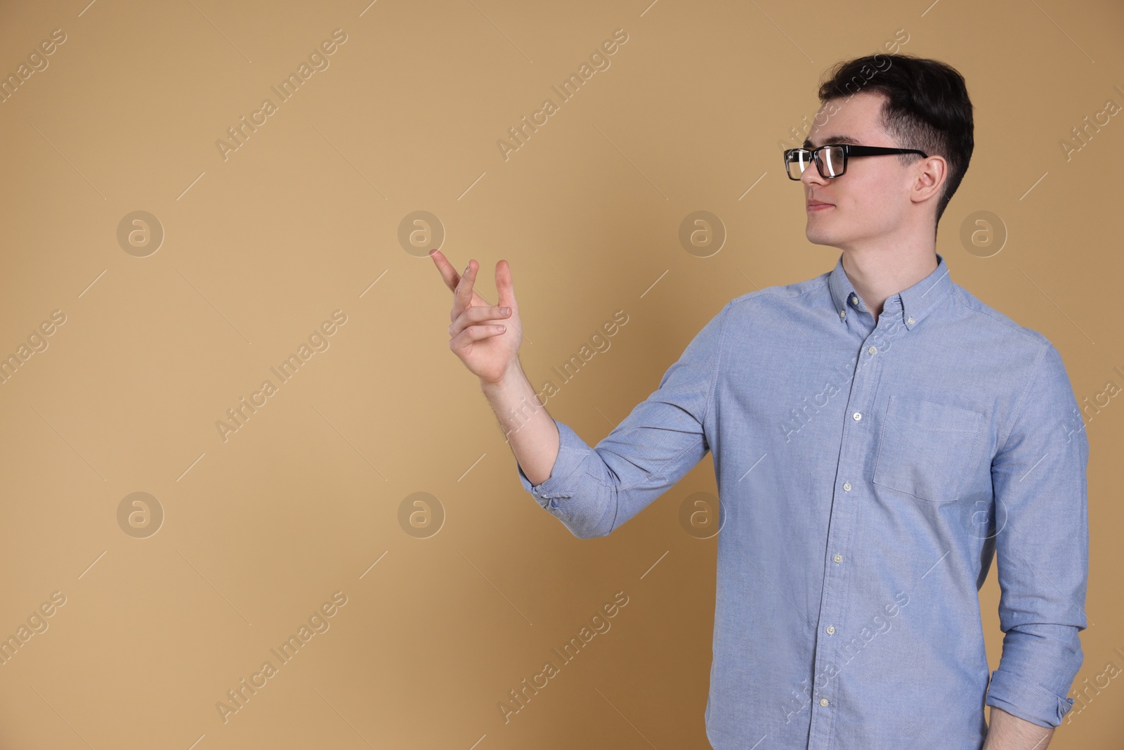 Photo of Portrait of handsome young man gesturing on beige background, space for text