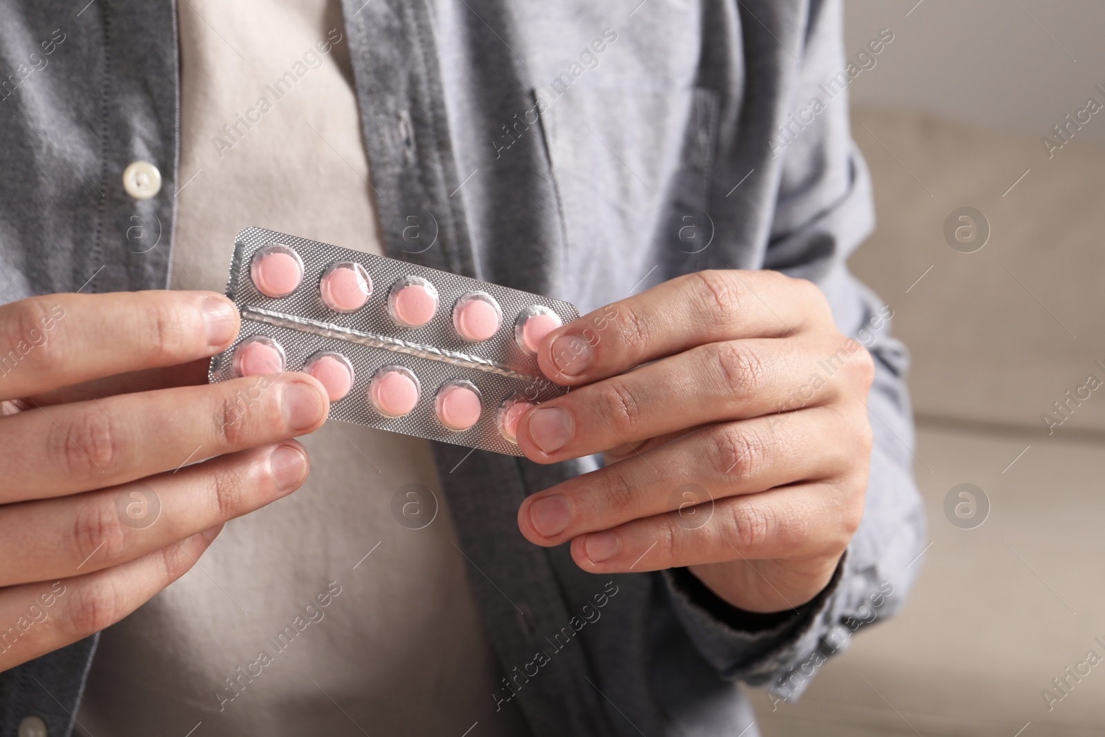 Photo of Man holding blister with pills, closeup view