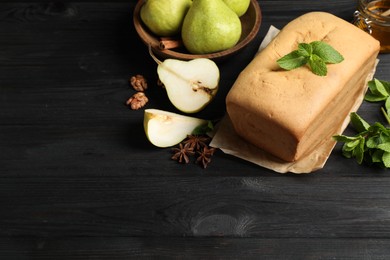 Composition with pear bread on black wooden table, space for text. Homemade cake