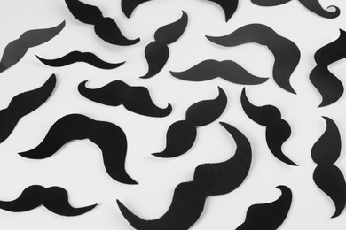 Photo of Fake paper mustaches on white background, flat lay