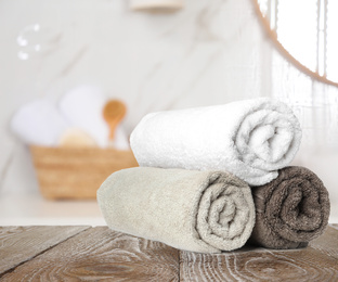 Image of Fresh towels on wooden table in bathroom