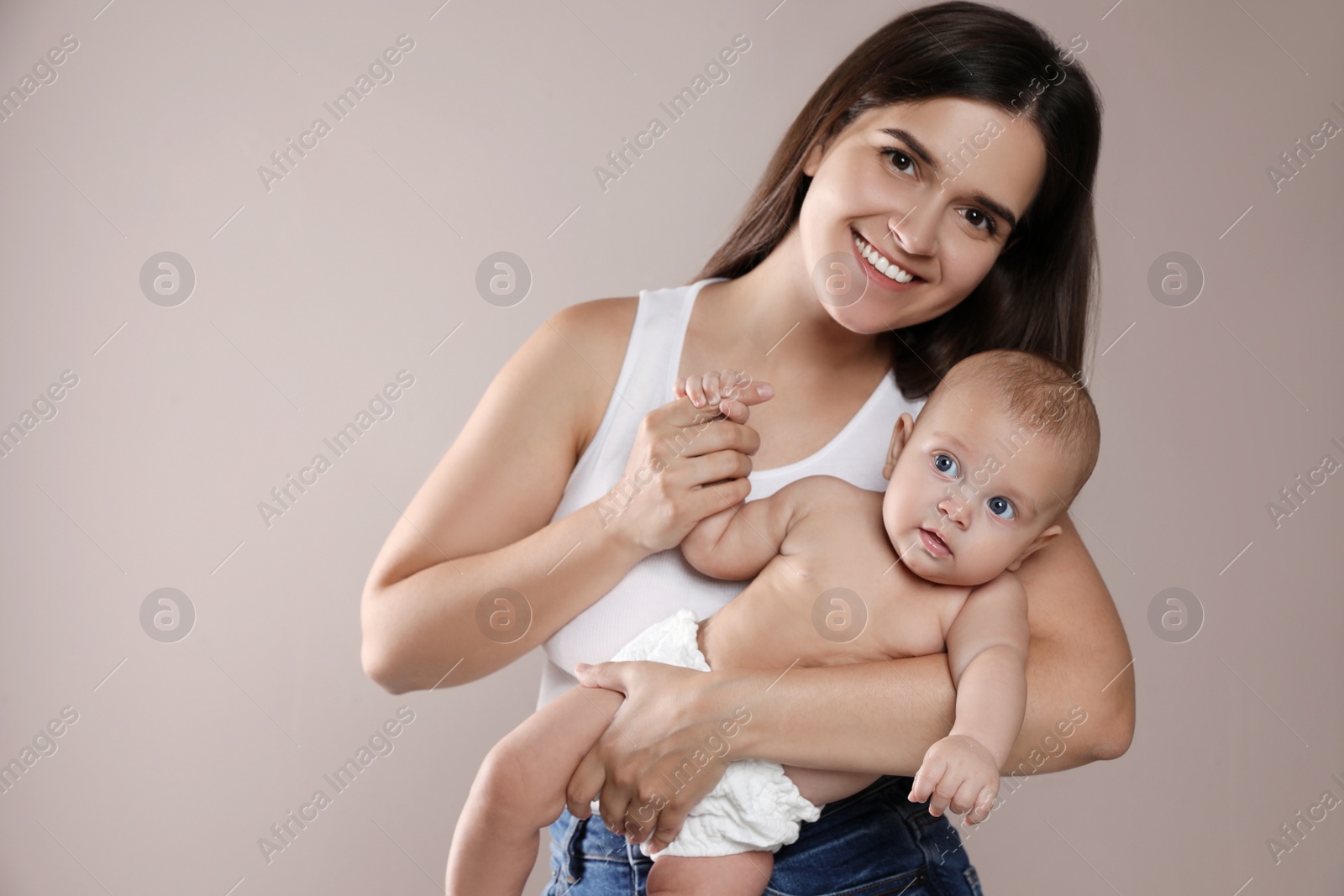 Photo of Beautiful mother with her cute baby on beige background