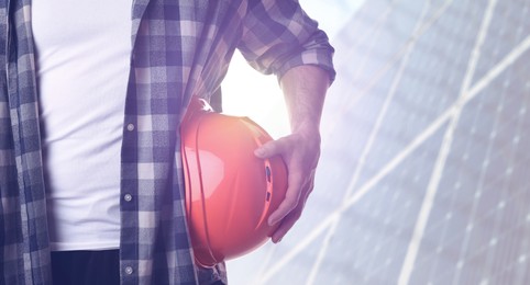Image of Man with orange hard hat at construction site, closeup. Space for text 