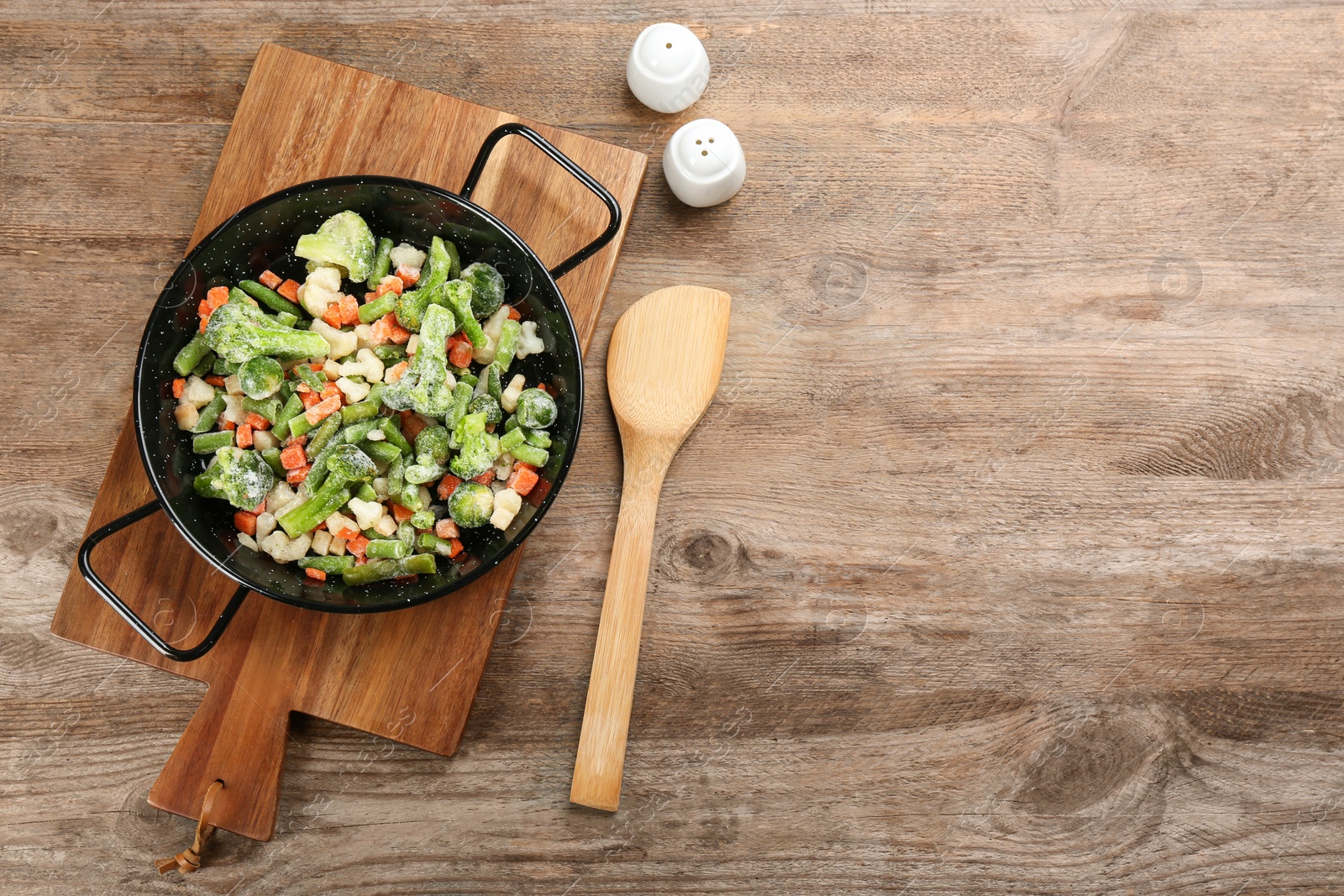 Photo of Tasty frozen vegetable mix on wooden table, flat lay. Space for text