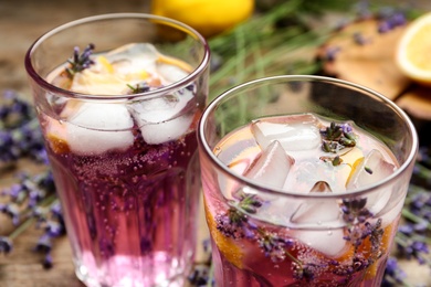 Photo of Fresh delicious lemonade with lavender on wooden table, closeup