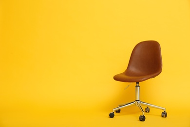 Modern office chair on yellow background. Space for text