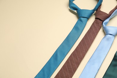 Photo of Different neckties on beige background, above view. Space for text