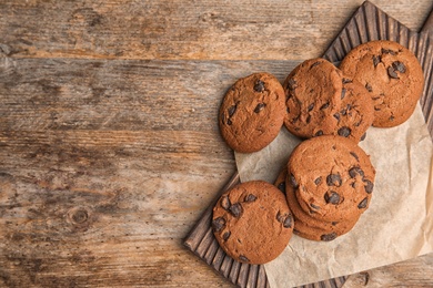 Photo of Chocolate chip cookies on wooden background, top view. Space for text