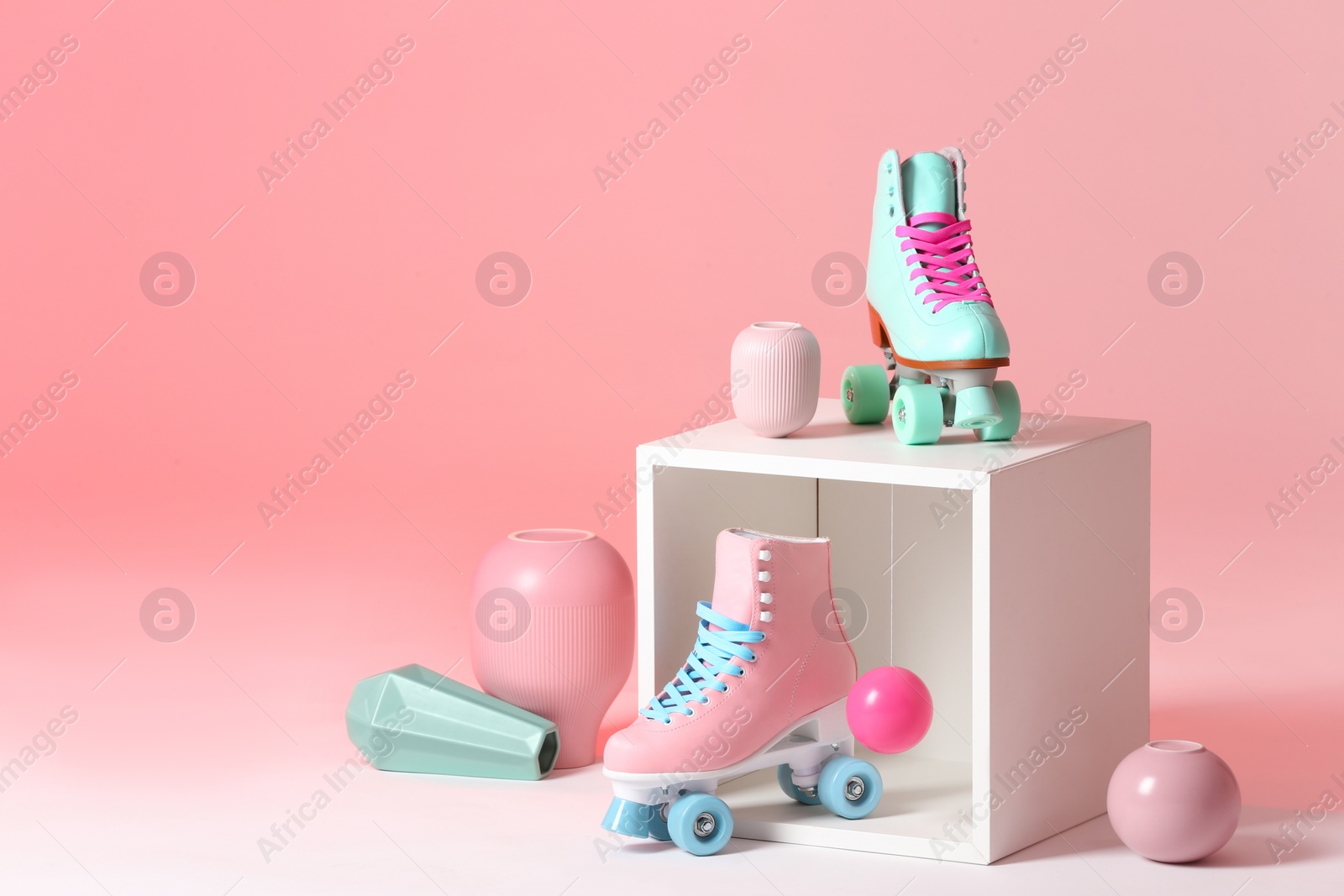 Photo of Composition with vintage roller skates and storage cube on color background. Space for text