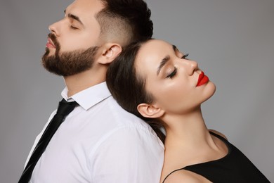Photo of Handsome bearded man with sexy lady on grey background
