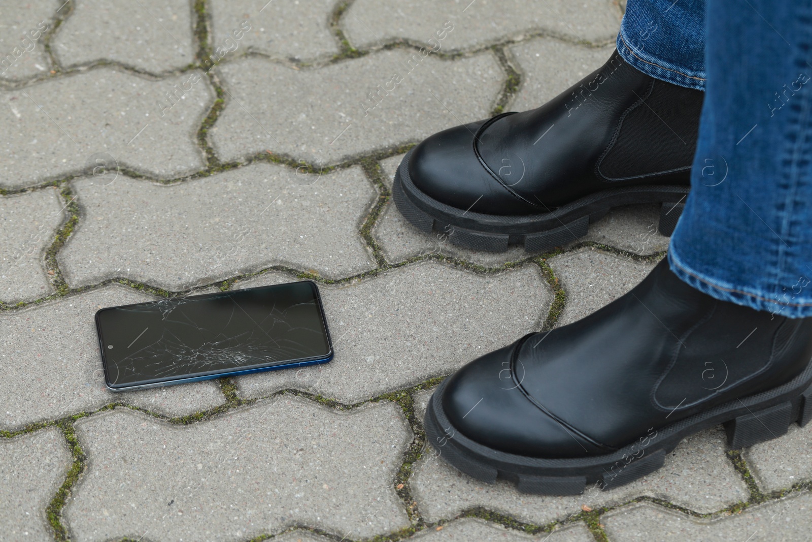 Photo of Woman near dropped smartphone on pavement, closeup. Device repairing