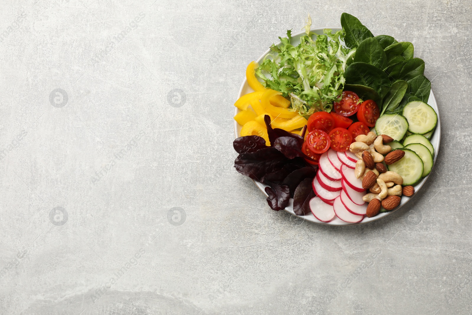 Photo of Balanced diet and vegetarian foods. Plate with different delicious products on grey table, top view. Space for text