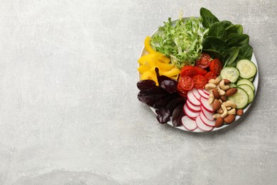 Photo of Balanced diet and vegetarian foods. Plate with different delicious products on grey table, top view. Space for text