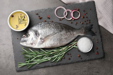 Fresh dorado fish and spices on grey table, flat lay