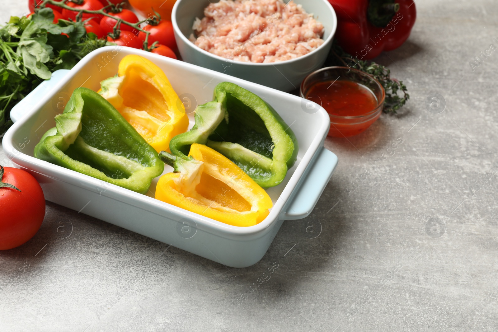 Photo of Making stuffed peppers. Vegetables and ground meat on grey table