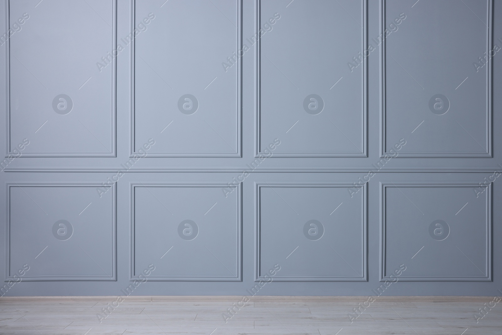 Photo of Empty room with light blue wall and wooden floor